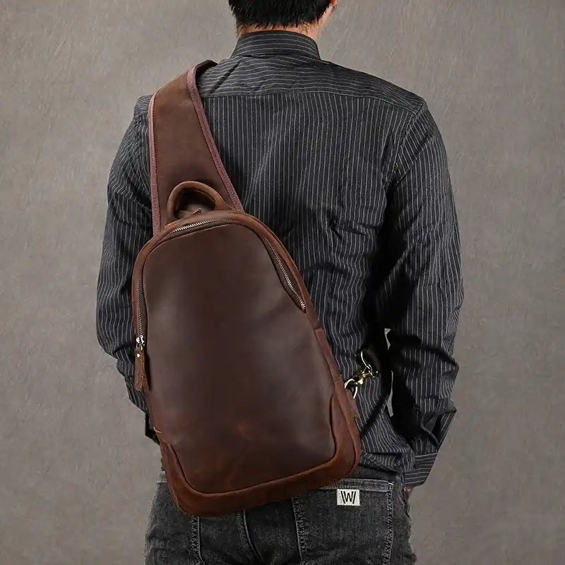 Man wearing a brown leather backpack, highlighting the modern and elegant bag design.