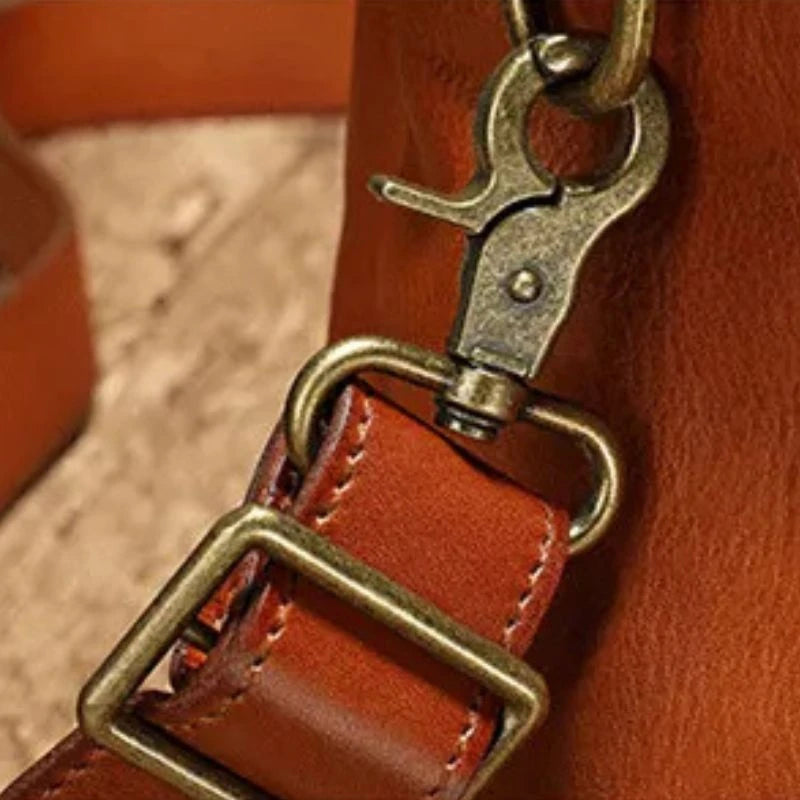 Detail of a metal clasp on a brown leather strap, reflecting the quality features in fashion accessories.