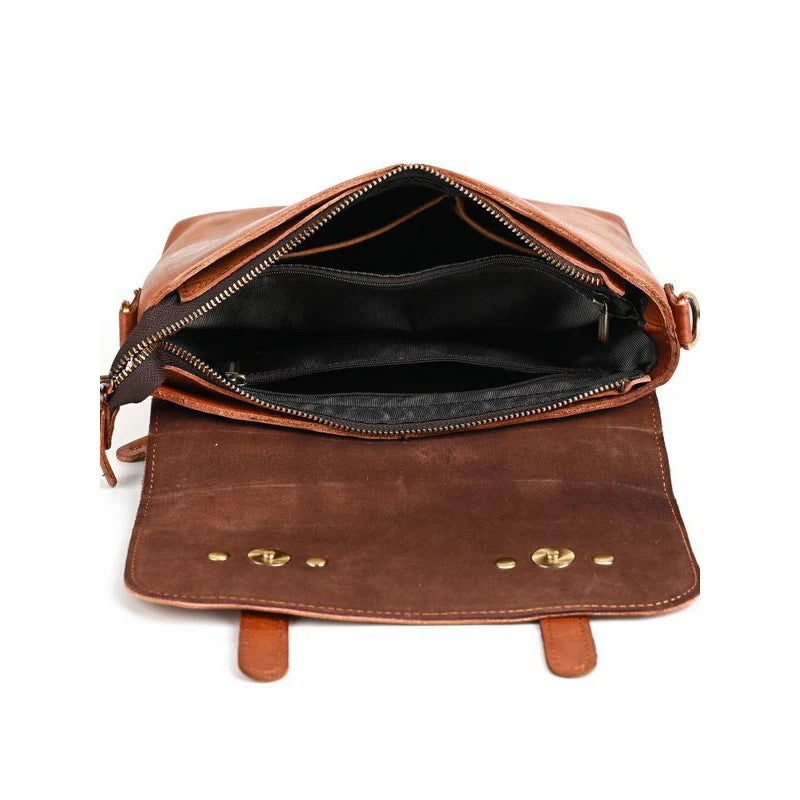 Spacious interior of a brown leather shoulder bag with zipper and snap closure.