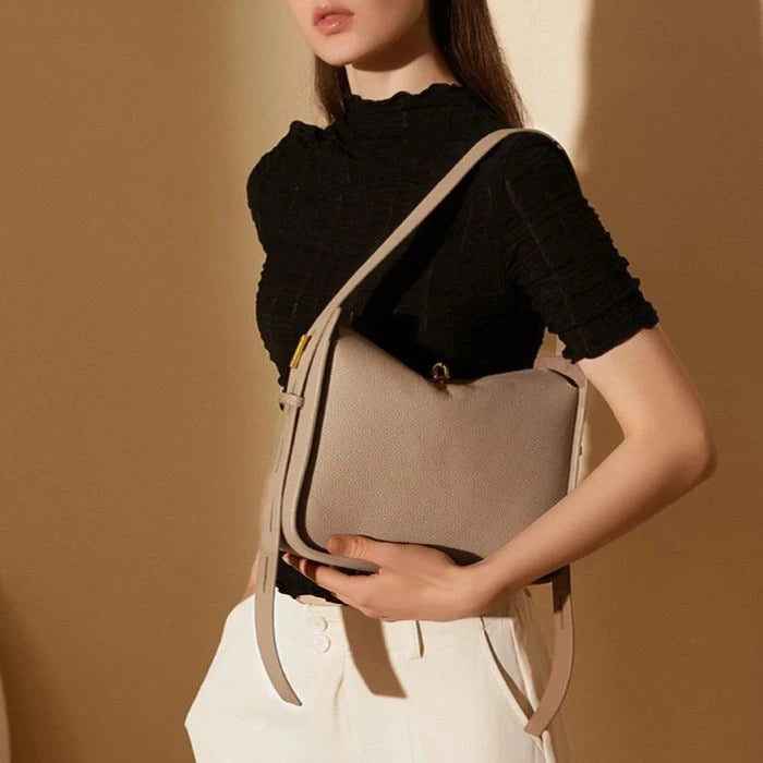 Model holding an elegant gray leather bag on her shoulder