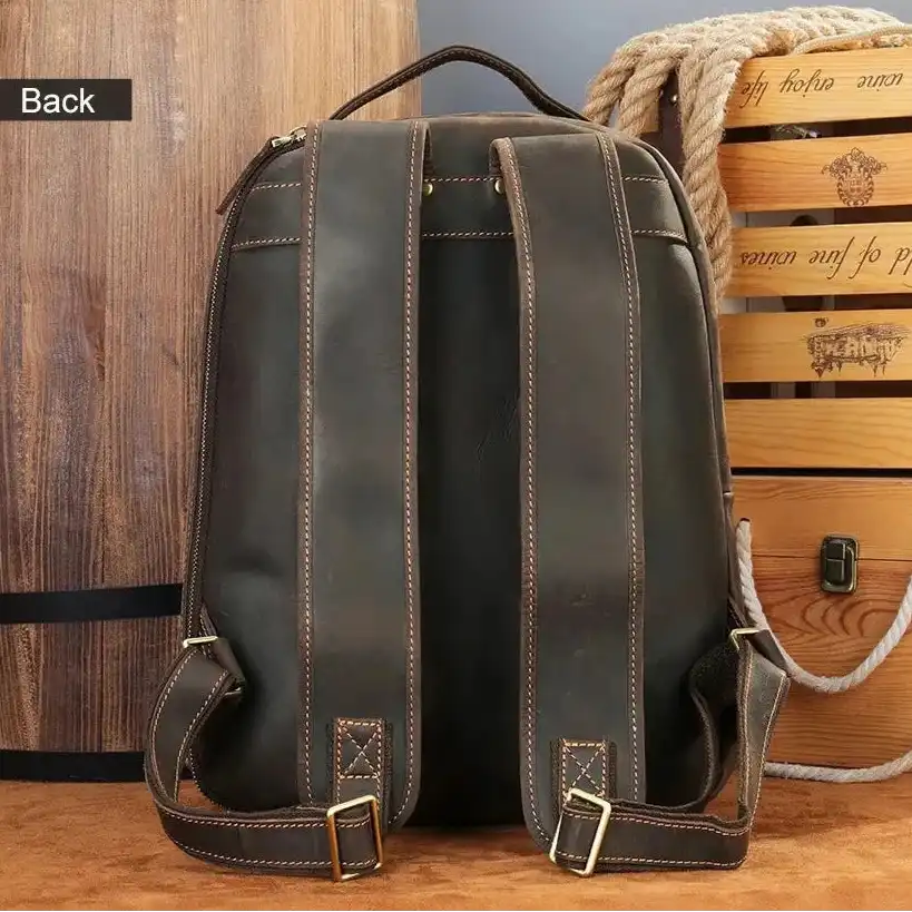 Brown leather backpack back view, with adjustable straps and soft handle.