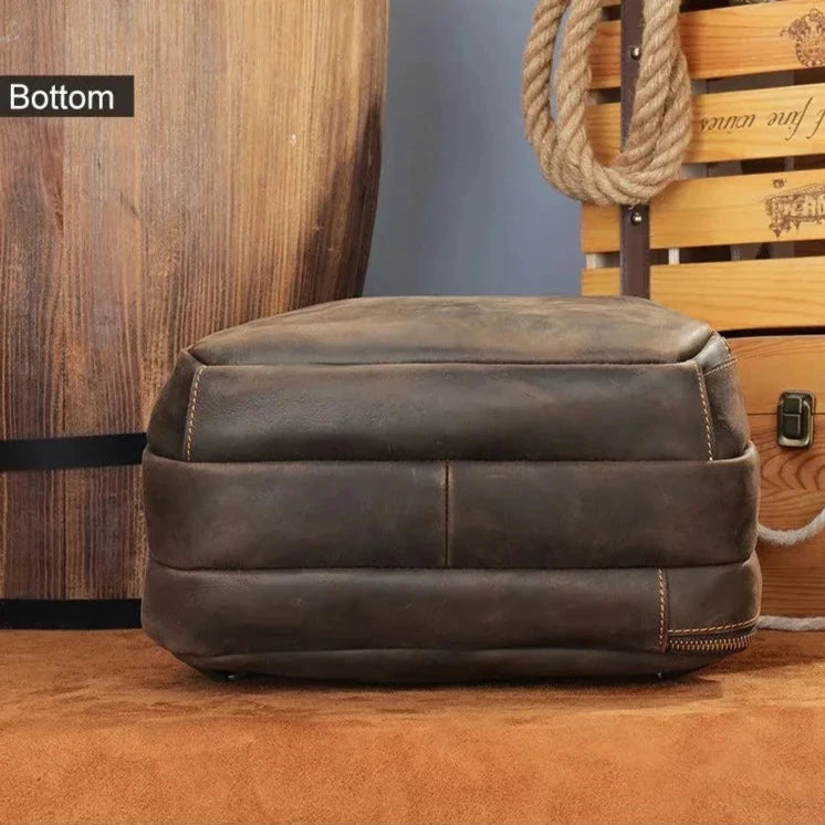 Brown leather backpack bottom view, highlighting its elegant material and fine stitching.