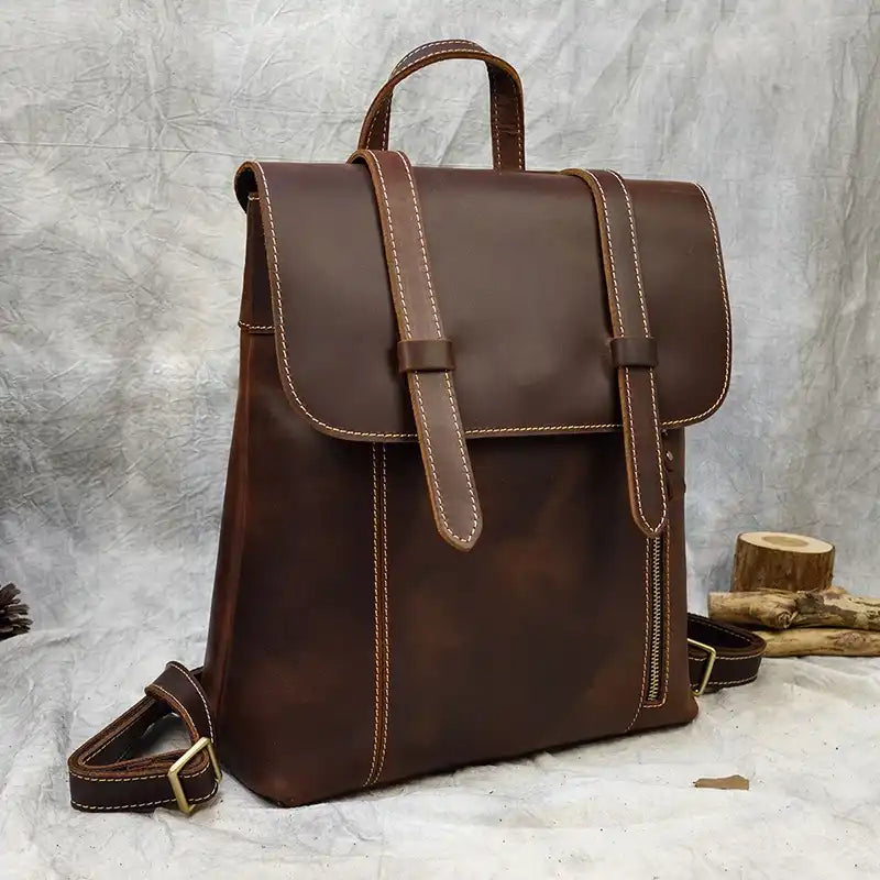 Brown leather backpack with light stitching details. Modern and functional design, front view.