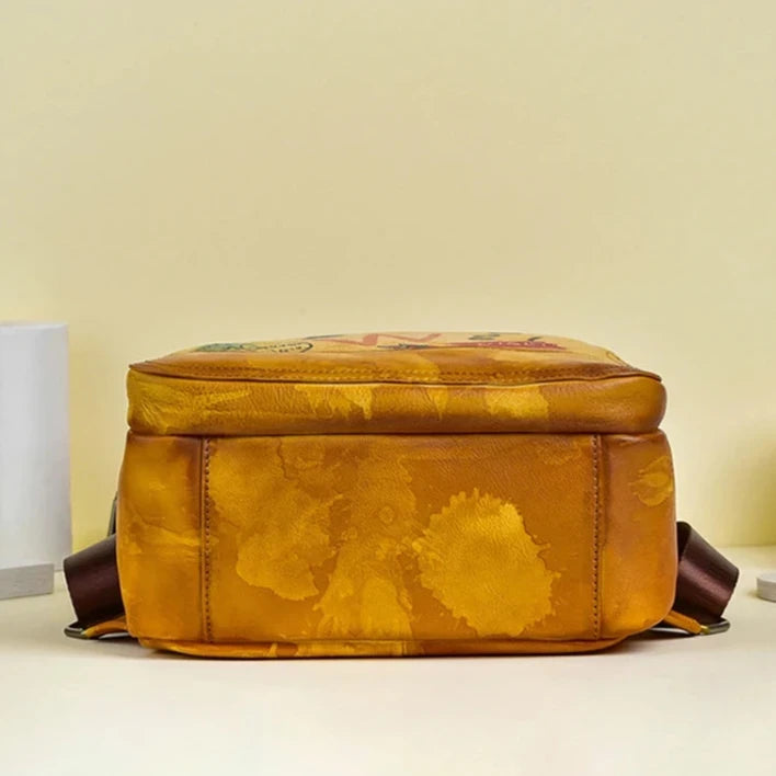 An orange leather bag with colorful details and artistic spots, bottom view.