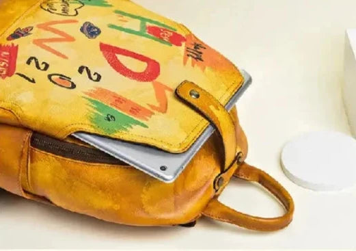 Leather backpack with colorful print and partially visible laptop inside.