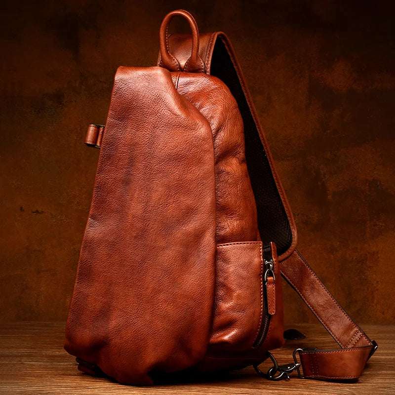 Brown leather shoulder bag with a modern organic shape and elegant design, front view.