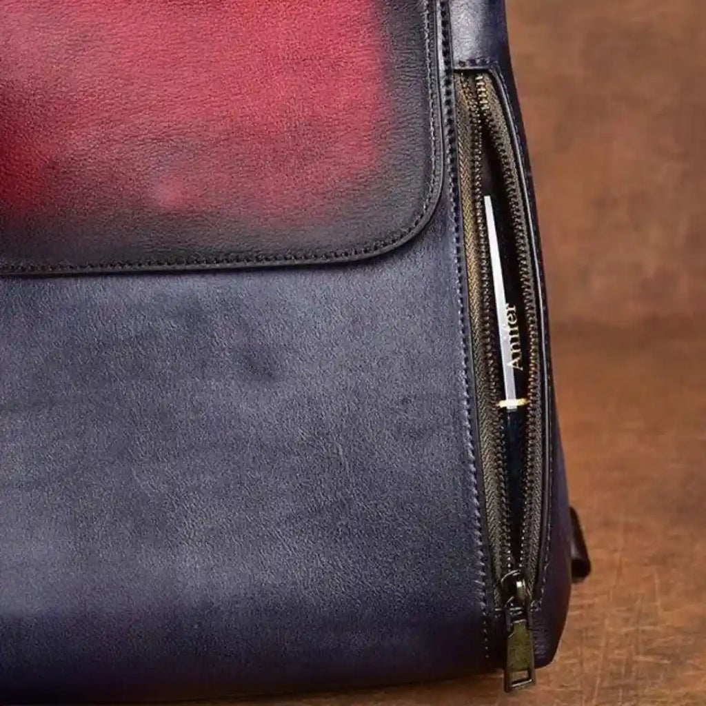 an elegant leather bag in blue and red colors, with zipper details, ideal for sophisticated fashion accessories.