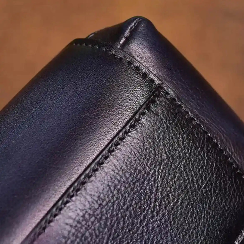 Detail of a black leather material, highlighting the stitching and texture of the leather showing the quality of the finish.