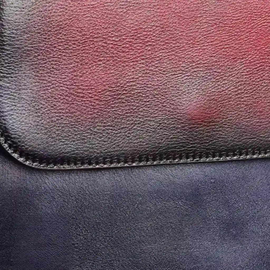 a leather surface with textures in shades of blue and red, showcasing fine stitching details.