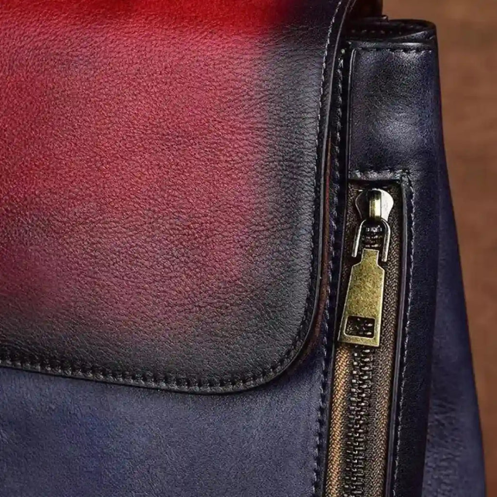 Detail of an elegant leather bag, showcasing a contemporary zipper design with red and blue tones.