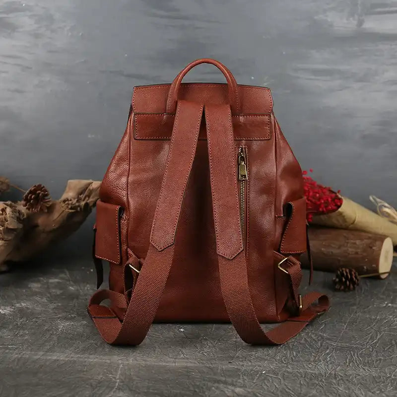 red brown leather backpack with adjustable straps and back zipper pocket, back view.