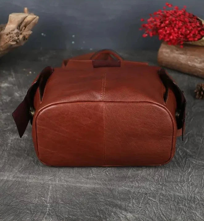 A red brown leather bag, viewed from below, highlighting its durable and sophisticated design. 