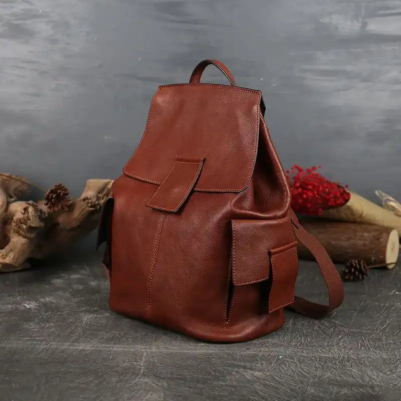 Durable red brown leather backpack featuring spacious compartments, front view.