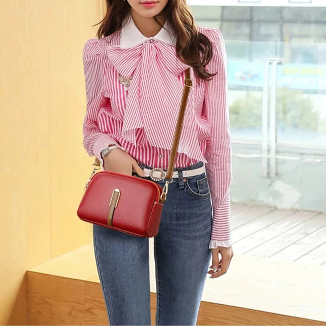 Fashionable woman wearing a red leather crossbody bag.