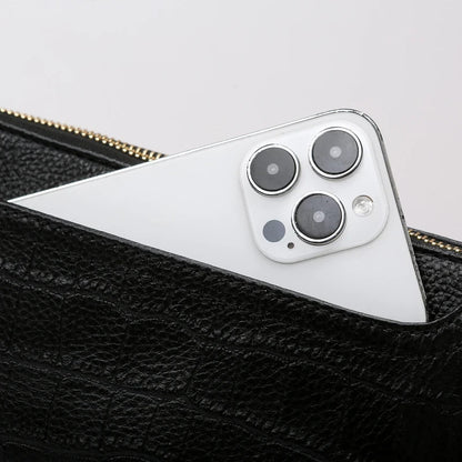 a smartphone, partially hidden in a black leather bag pocket. 