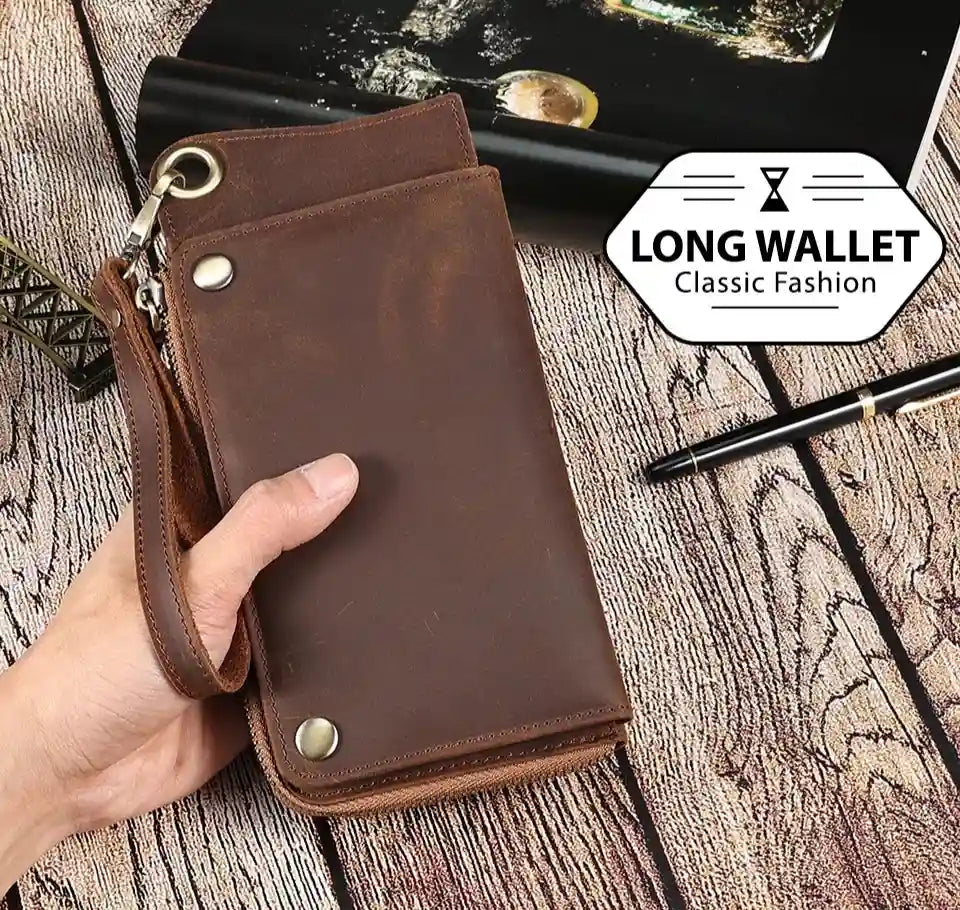 a brown leather wallet with wrist strap being held by a hand, highlighting its elegant design and functionality.