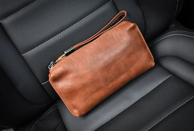 Stylish leather wallet in brown color on a black leather seat.