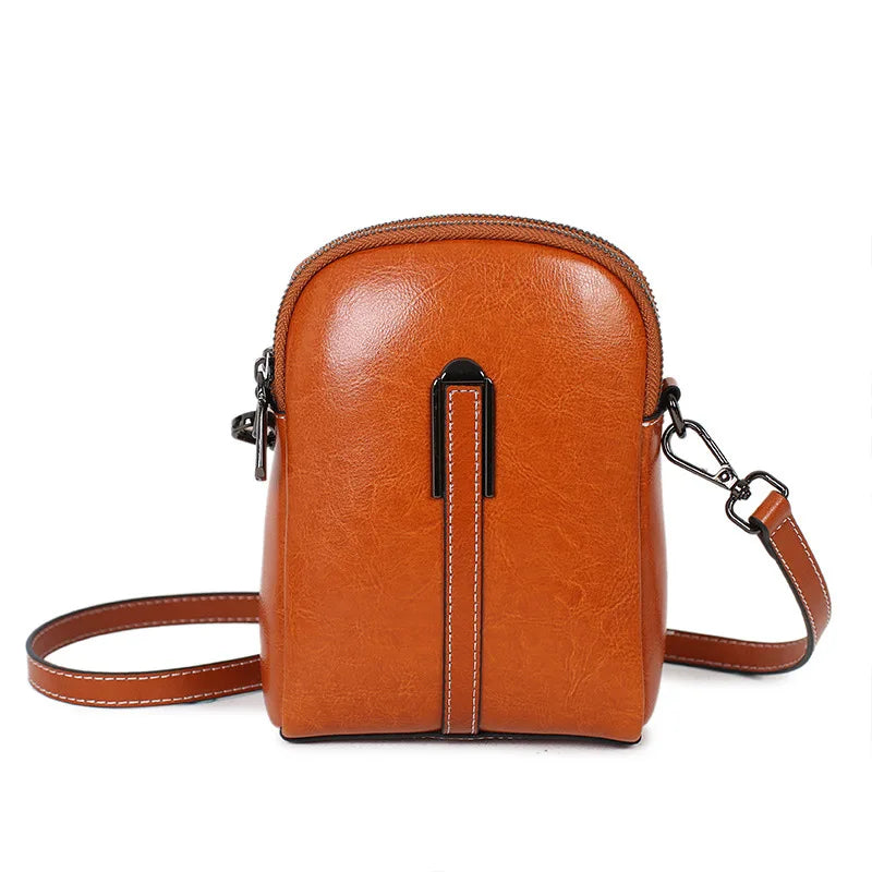Chic caramel color crossbody bag featuring a sleek design and zipper closure and leather strap- front view