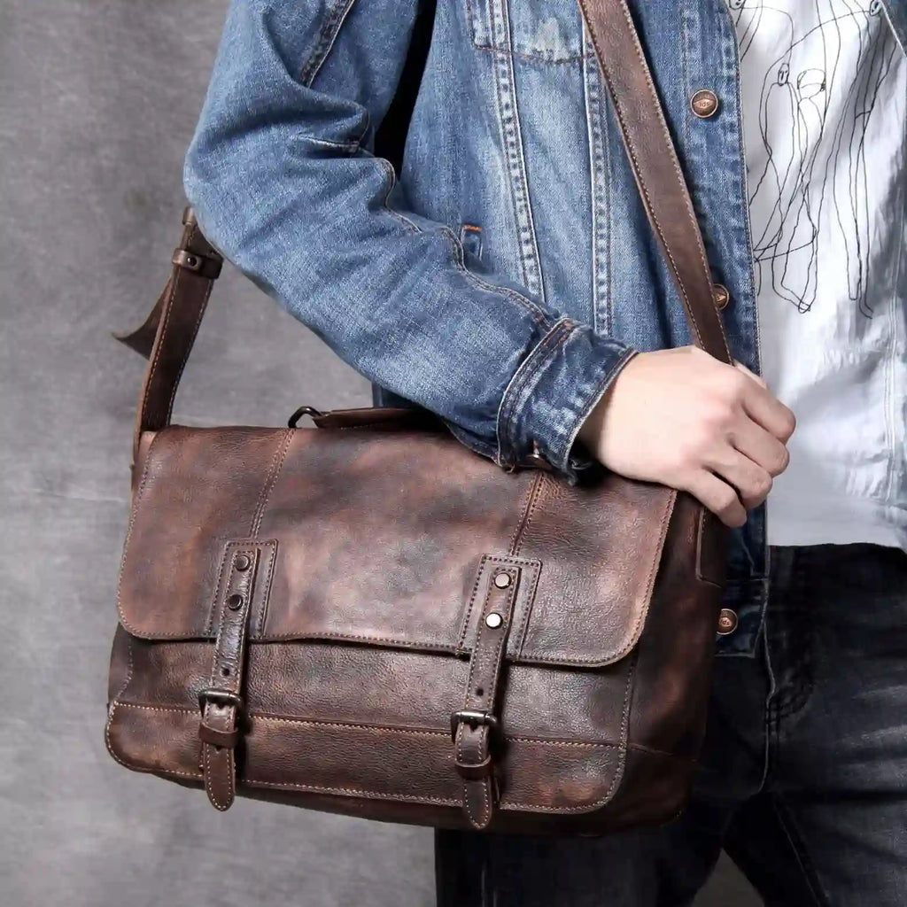 a man holding a brown leather bag. The bag has vintage details and goes well with casual clothes.