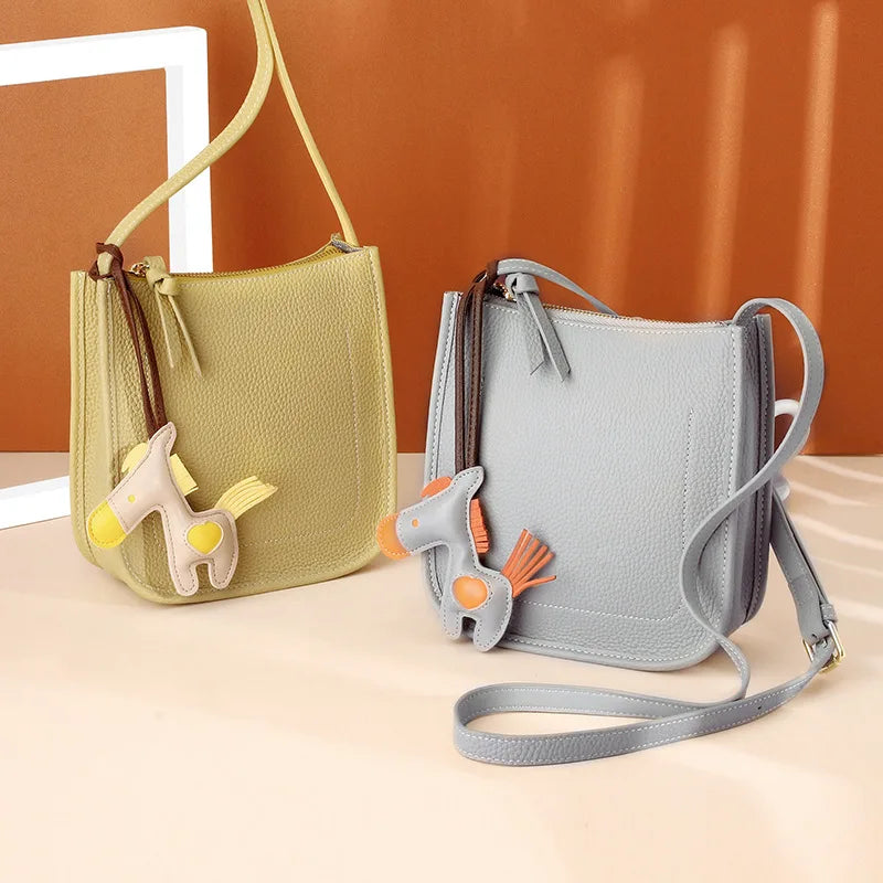 Fashionable crossbody bags in yellow and grey with unique colorful leather horse charm