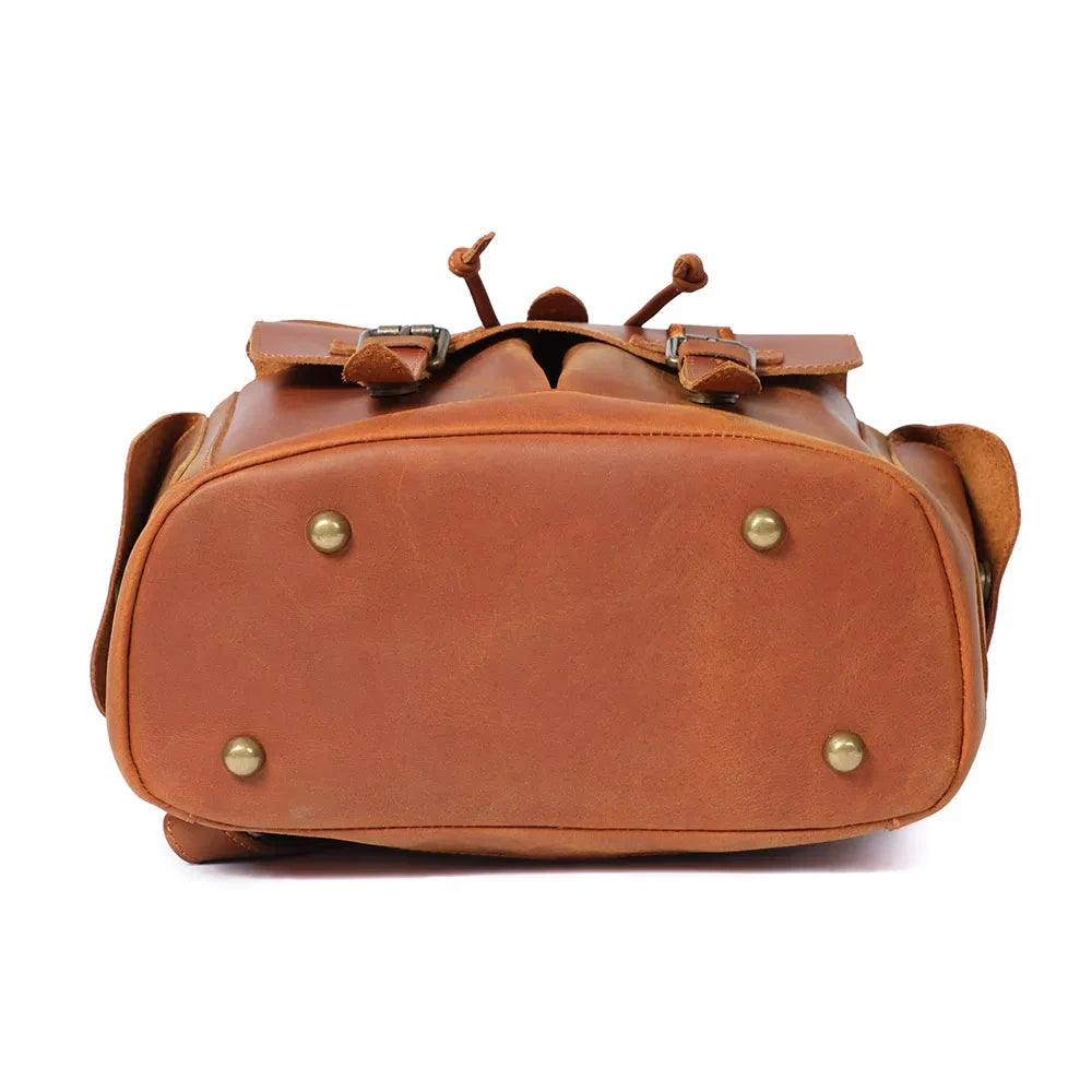 Bottom view of a stylish leather backpack with brass feet.