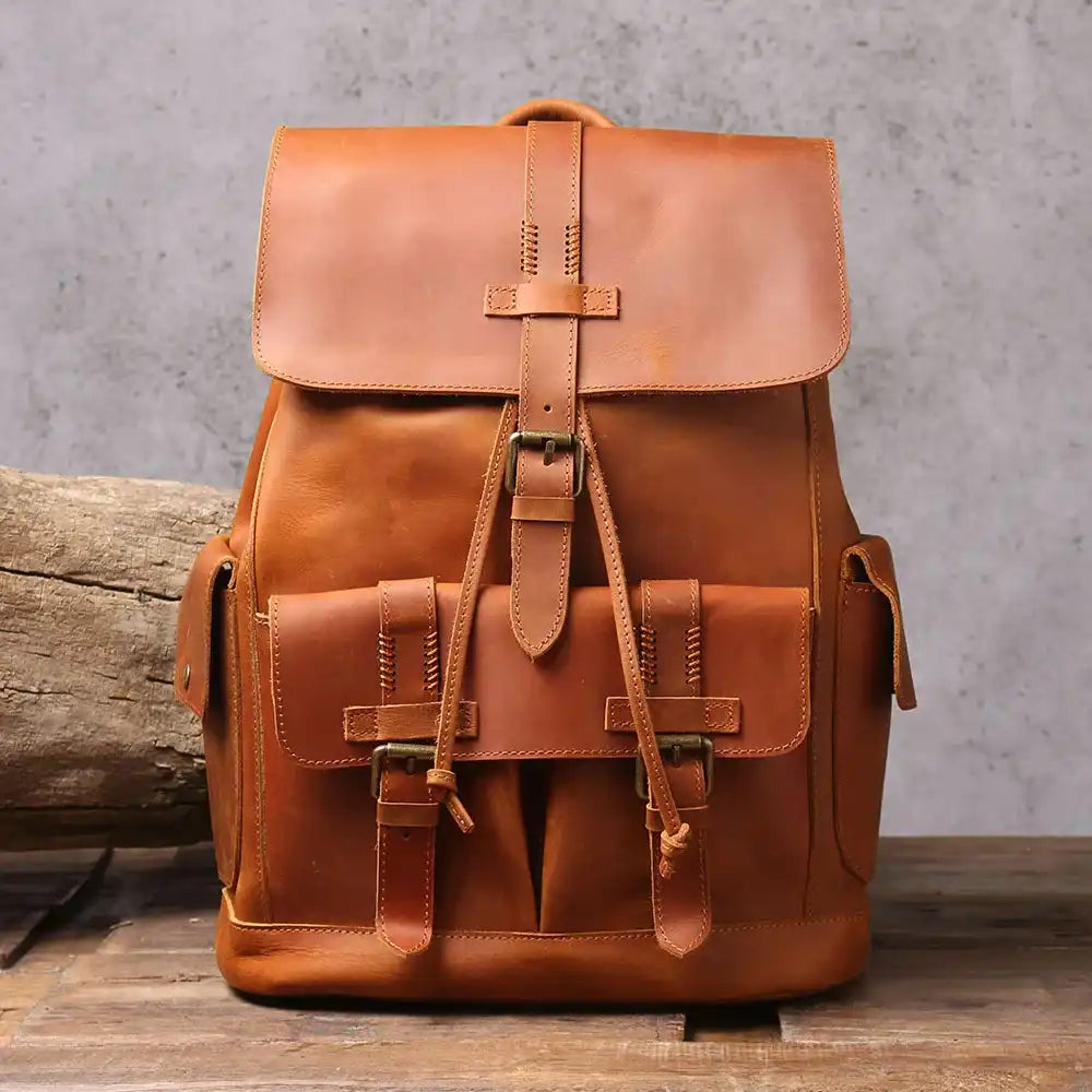 Elegant brown leather backpack, ideal for travel, with buckle and visible stitching details and pockets - front view