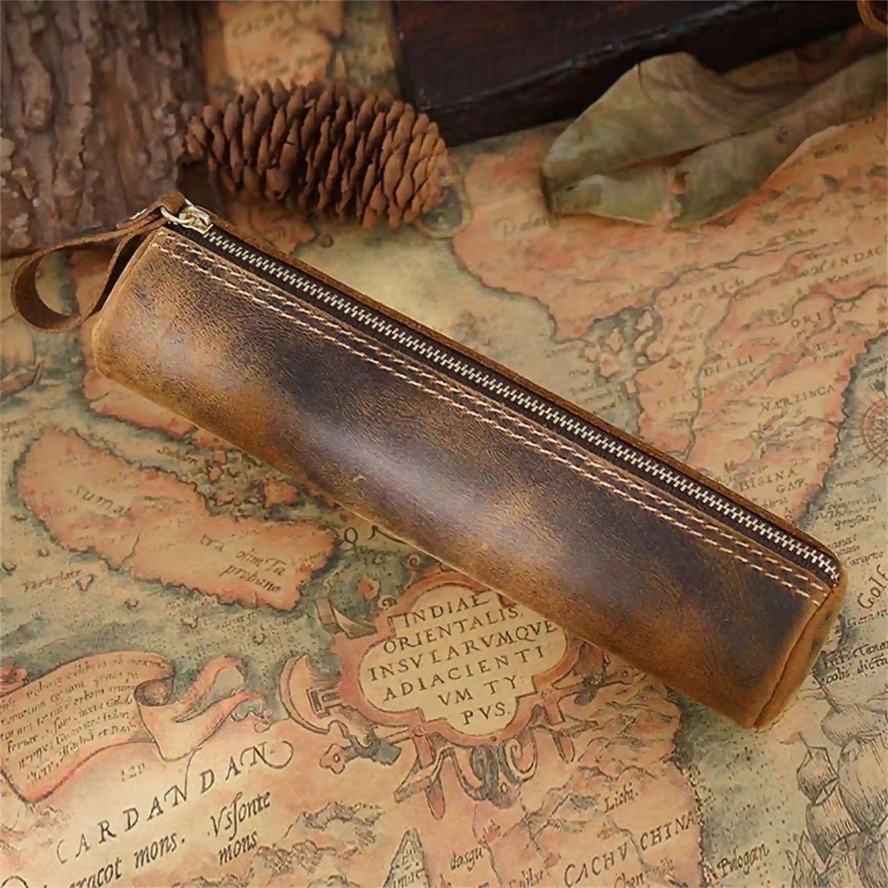 Elegant brown leather pen case on an antique map, front view.