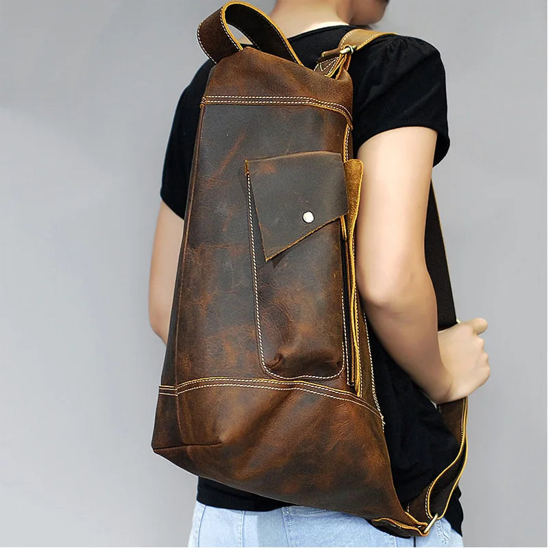 Stylish vintage brown leather backpack worn on a person's back.