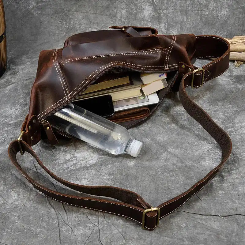 Organized leather bag displaying many items like a phone and water bottle.