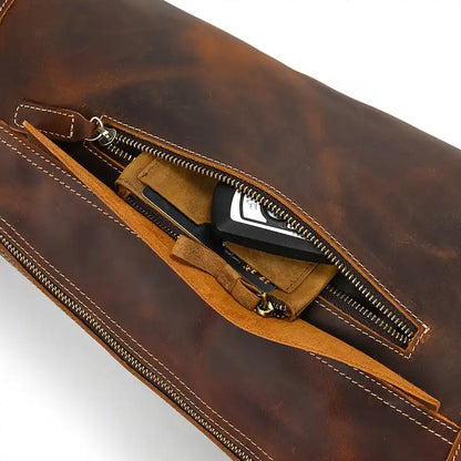 a dark brown leather bag with a zipper, showing the interior and organized objects.