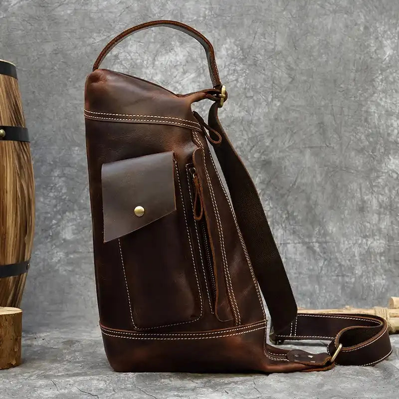 Side view of a vintage leather bag with a pocket and zipper.