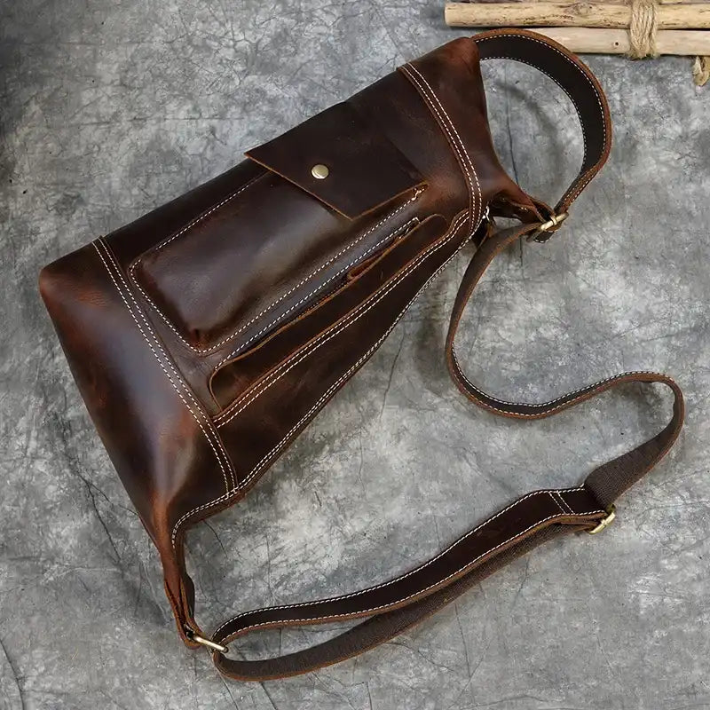 Stylish vintage brown leather shoulder bag with adjustable strap and front pocket.