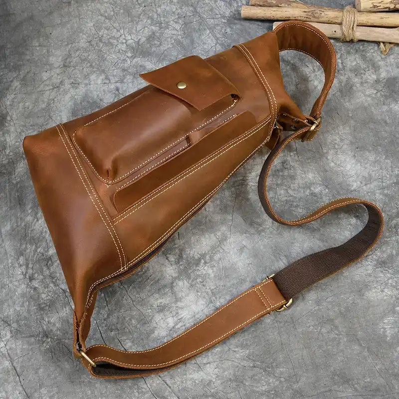 vintage light brown leather bag with pockets and adjustable strap.