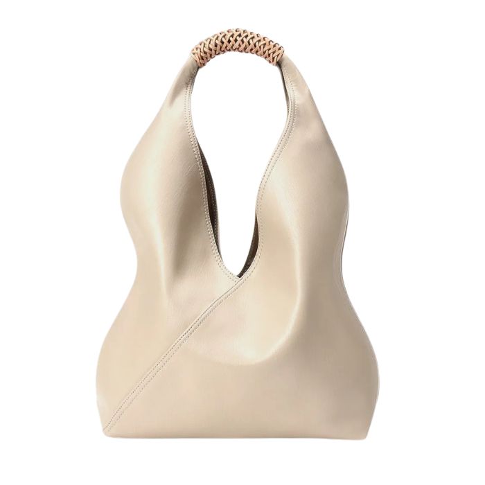 White leather bag with unique design and braided handle, front view.