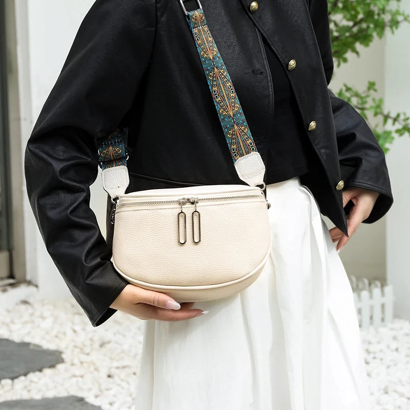  woman holding an elegant leather  shoulder bag with a patterned strap, ideal for everyday wear.