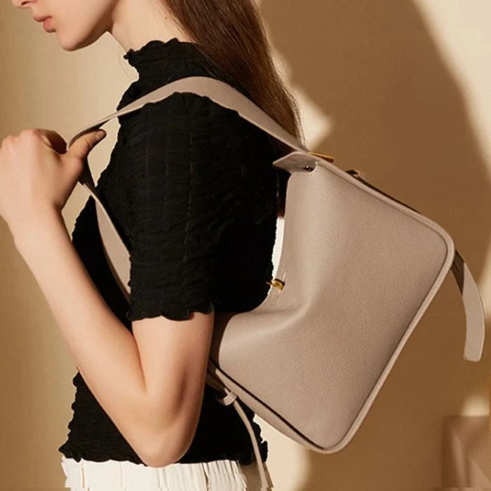 Elegant model showing off a gray leather bag that combines style and functionality.