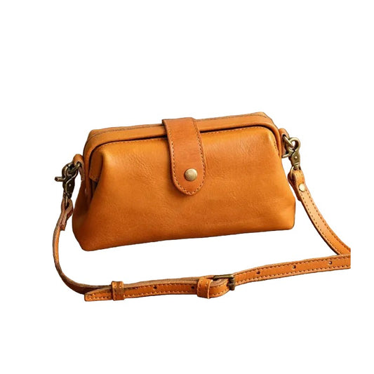 Brown leather handbag with adjustable strap on a white background, front view.