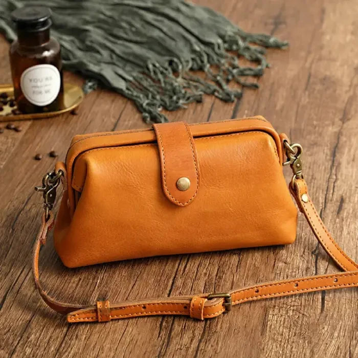 Yellow leather shoulder bag with leather adjustable strap and snap closure, front view.