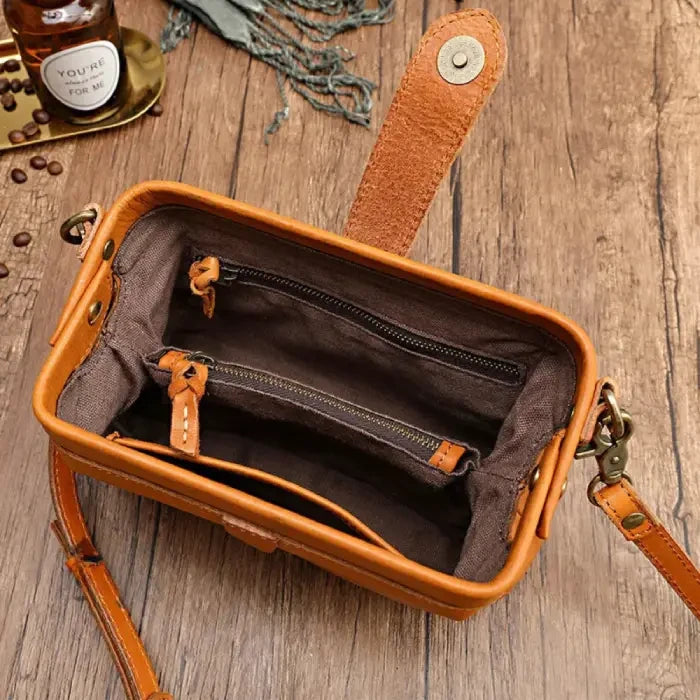 open brown leather bag with organized internal compartments, highlighting sophistication and functionality.