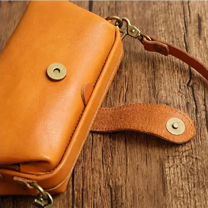 close-up view of an elegant yellow leather bag with a metal clasp.