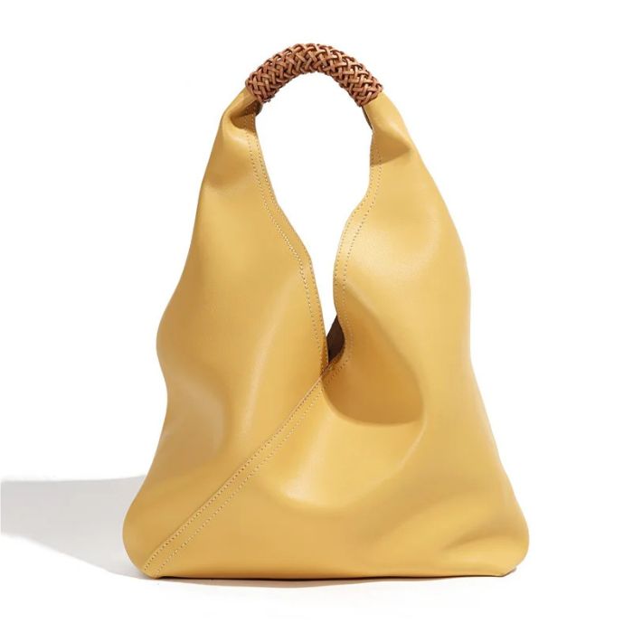 Yellow color leather bag with unique design and braided handle, front view.
