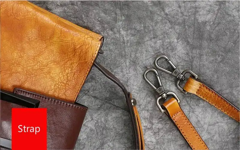 Detail of a leather bag handle with silver clasps, highlighting the texture and elegant color of the strap.