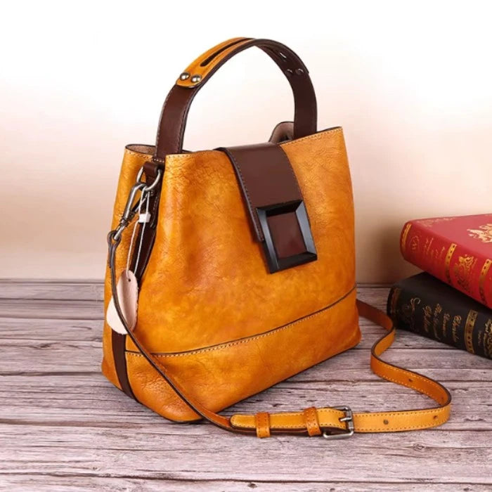 Orange women leather handbag with brown details and adjustable strap.